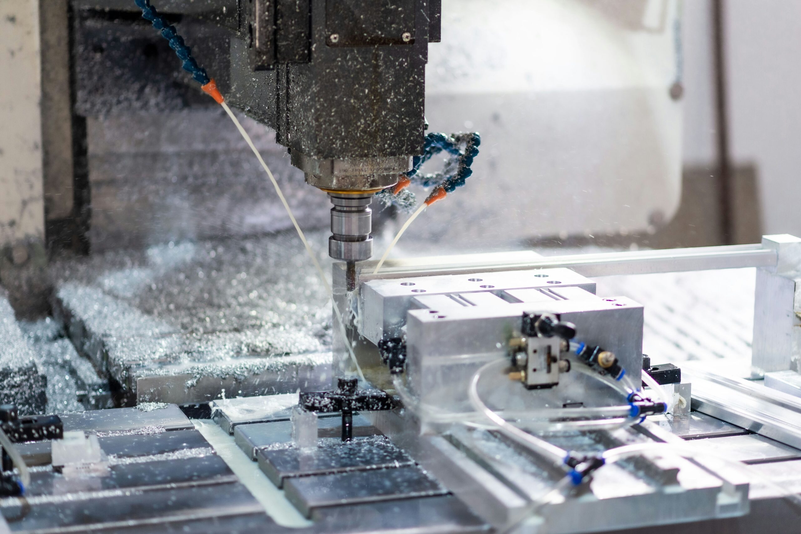 CNC milling cutter machining a metal workpiece under coolant