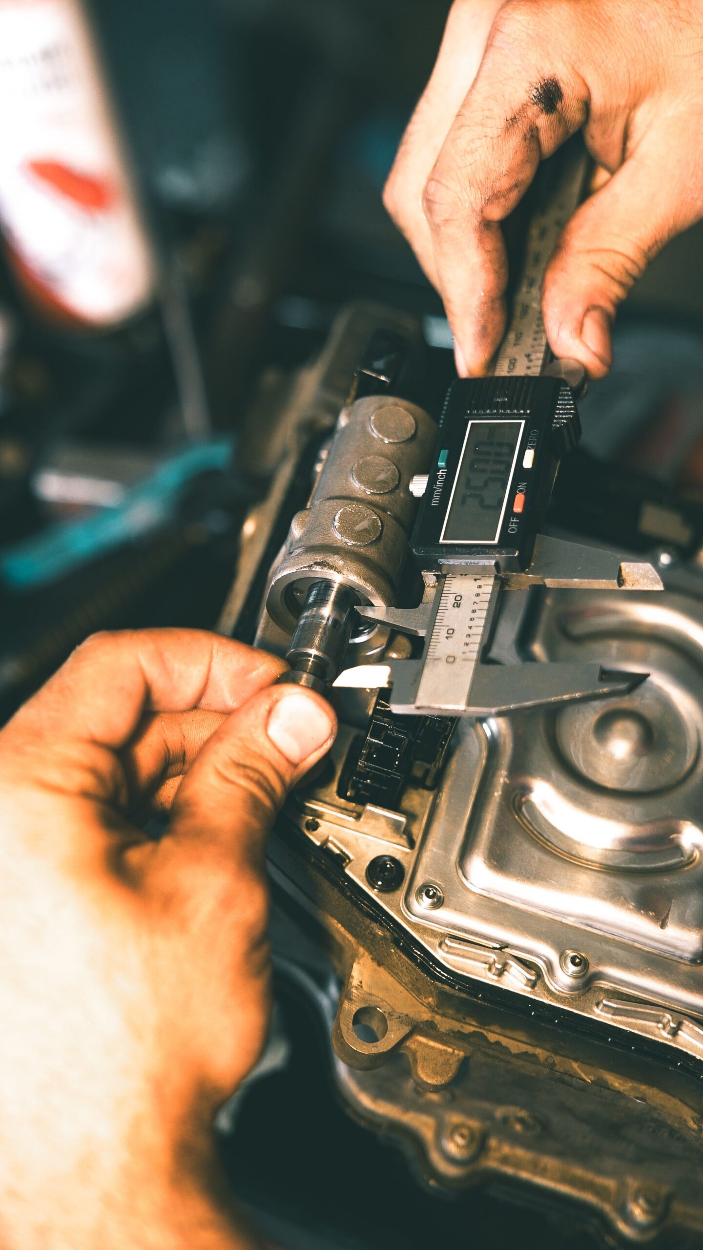 Hand using a digital caliper to measure a metal part